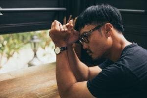 Man looks out window as he thinks about his own high functioning depression