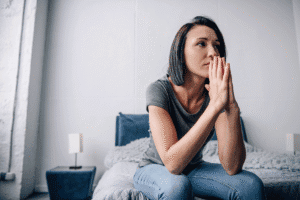 Woman sits on couch and thinks about complex trauma