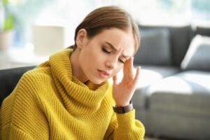 Woman rubs her head as she ponders how schizophrenia is diagnosed