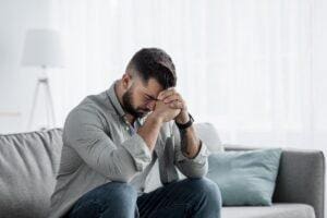 Person sits on couch and struggles with anxiety paralysis