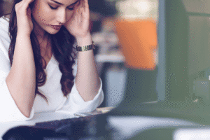 Woman sits at desk and struggles with symptoms of both ADHD and depression