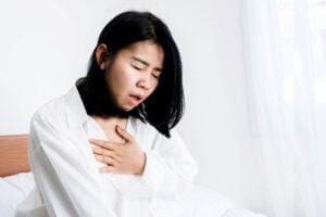 Woman grasps at chest as she struggles with panic disorder