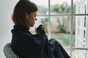 Woman sits on chair as she struggles with postpartum depression