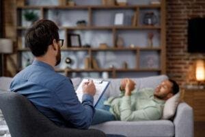 Man lays on couch and talks to therapist and learning how to prepare for first therapy session