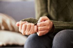 a person with generalized anxiety sits on a couch with hands together talking to therapist